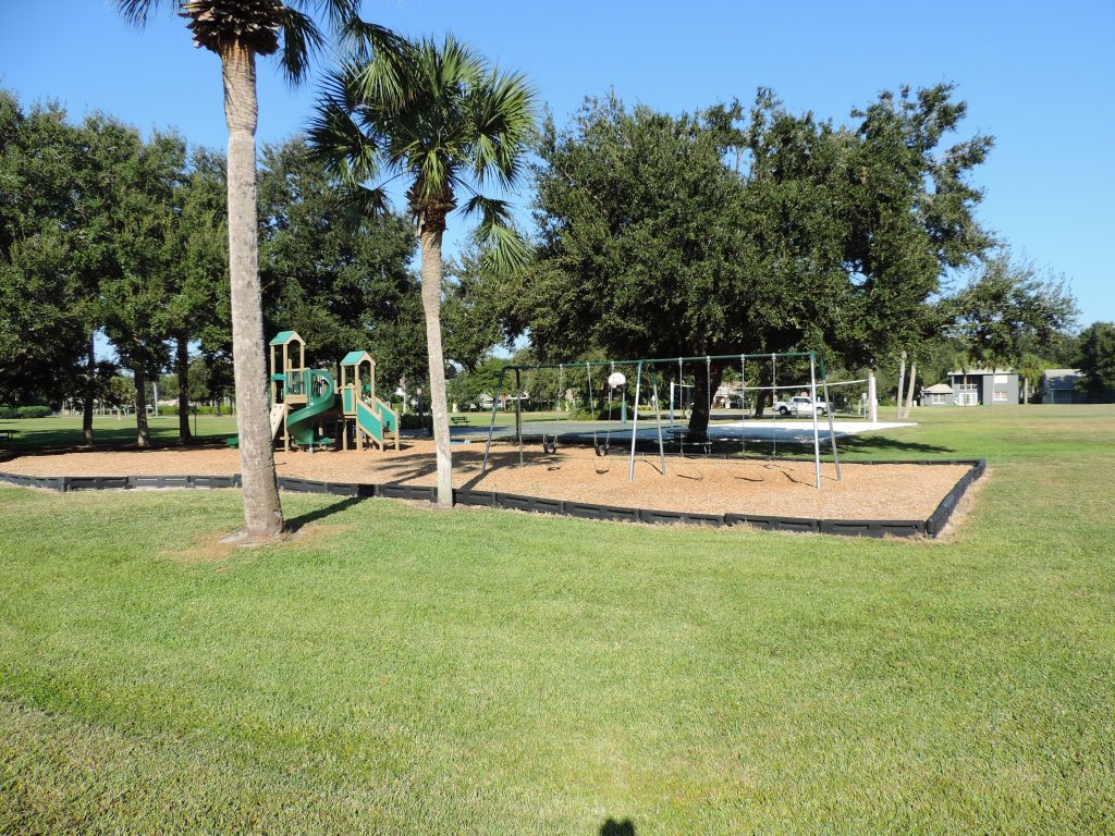 Picture of fun park showing trees, grass and playground